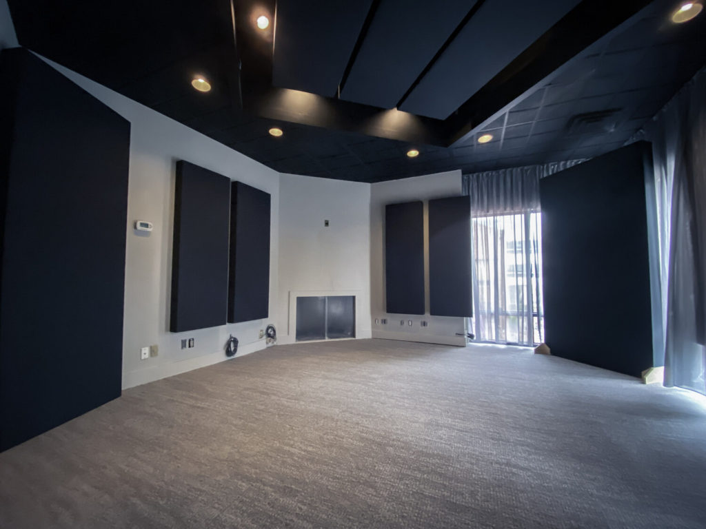 Home theater with acoustic absorption panels and treated ceiling clouds installed by Wave Media Systems