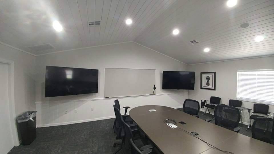 Conference room with dual wall-mounted displays and a whiteboard