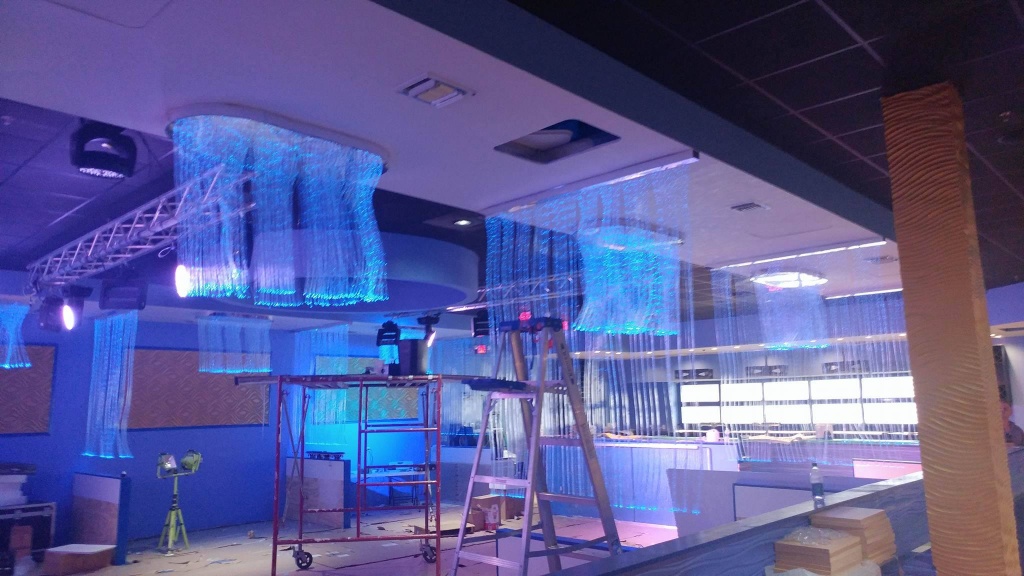 Illuminated fiber optic ceiling installation in a commercial space